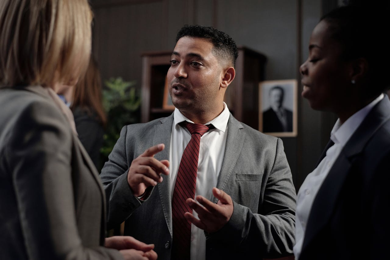The Art of Drawing Readers In: Your attractive post title goes here Diverse group of business professionals in suits having an engaging discussion in an office setting.