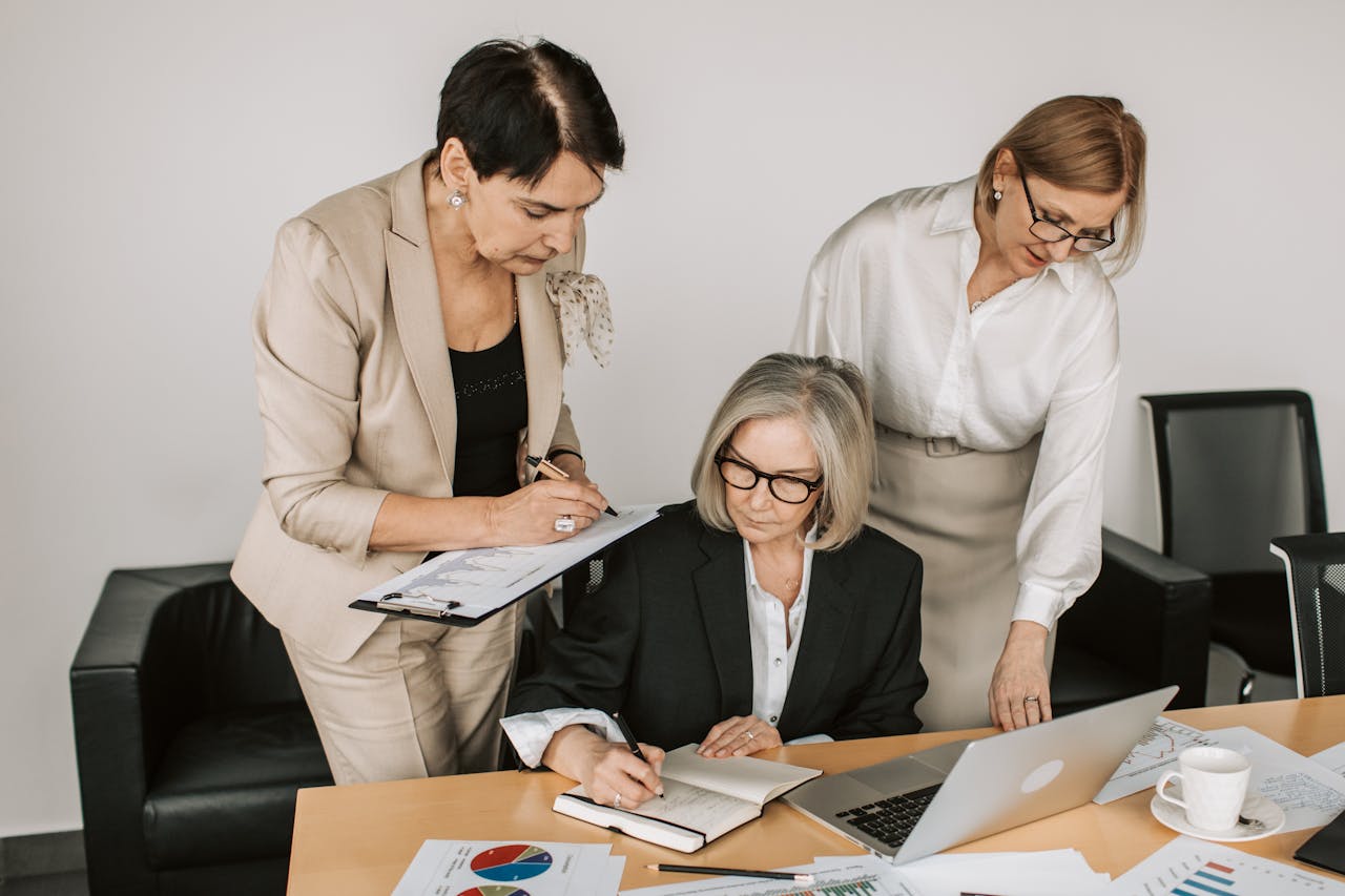 Mastering the First Impression: Your intriguing post title goes here Three professional women collaborating in a business meeting with documents and laptops.